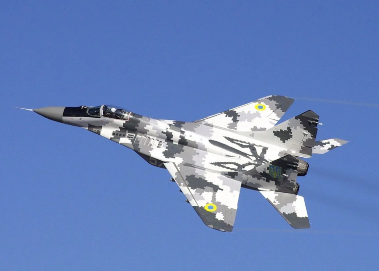 Ukrainian Air Force MiG-29 wearing digital camouflage soaring in clear blue skies.