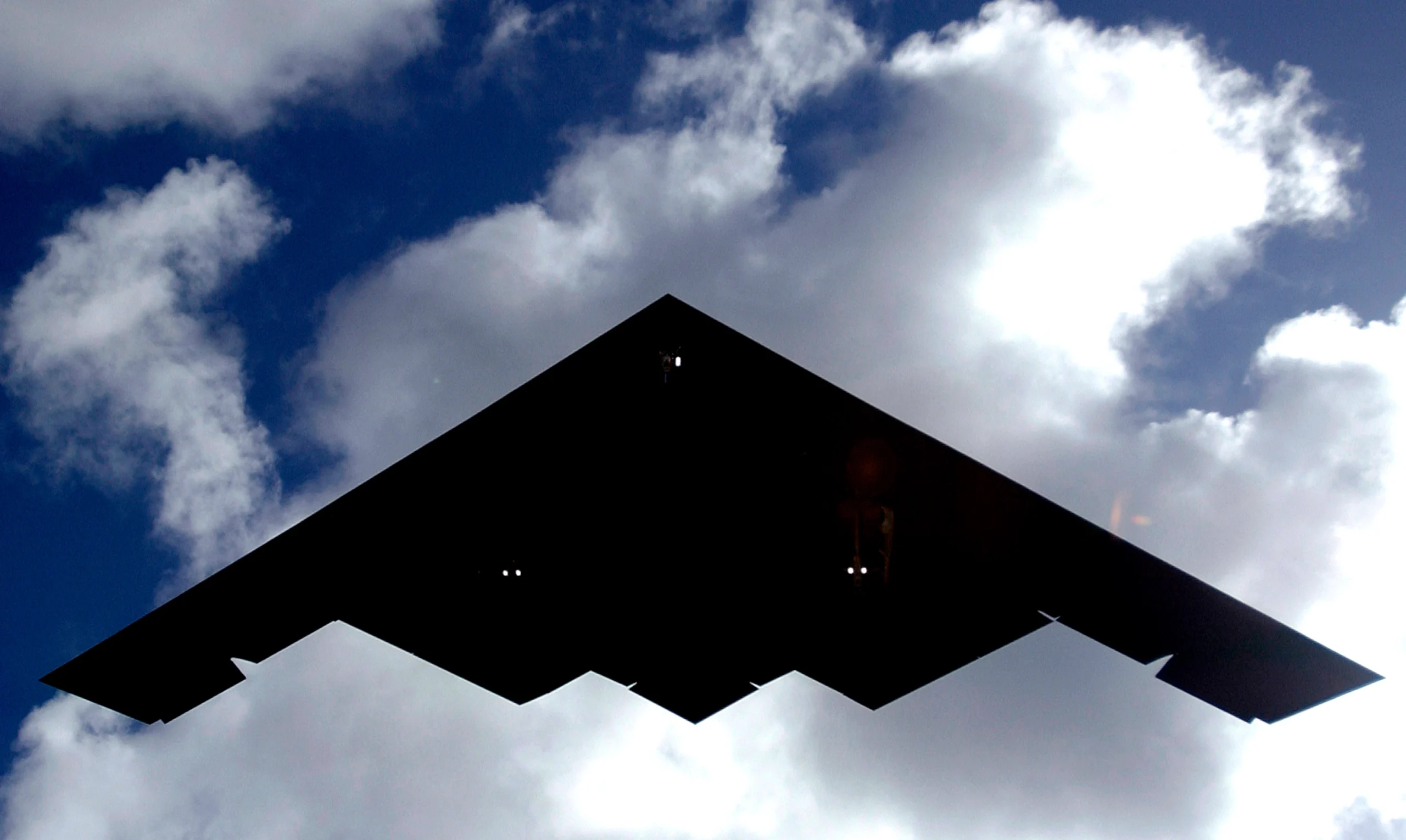 B-2 Spirit stealth bomber in flight displaying continuous flying wing design.