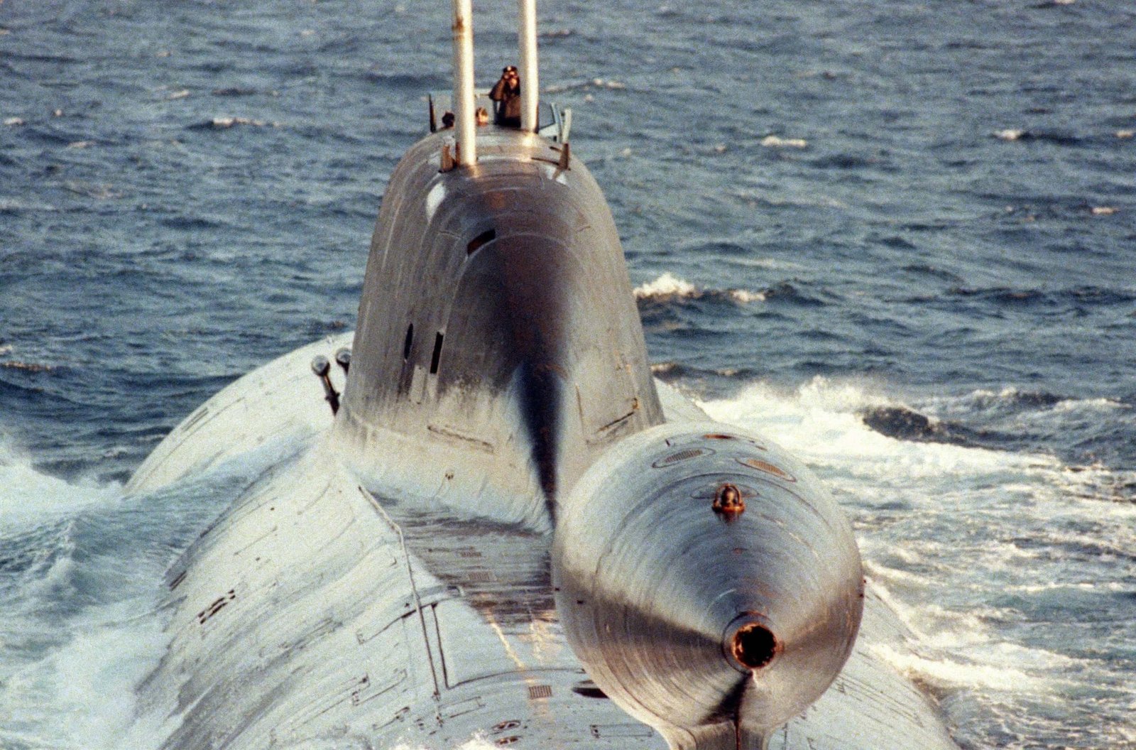 Russian submarine navigating surface waters and digital cyber threat graphics.