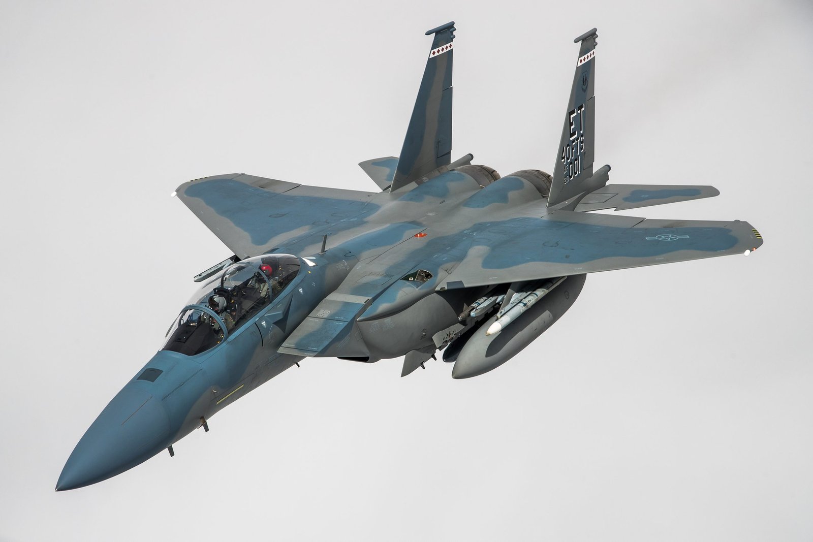 U.S. Air Force F-15EX Eagle II banking sharply in a clean sky, showcasing multiple weapon hardpoints.
