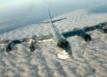 A Russian Tu-95 strategic bomber in flight, showcasing its swept wings and four turboprop engines.