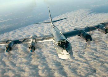 A Russian Tu-95 strategic bomber in flight, showcasing its swept wings and four turboprop engines.
