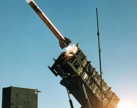 MIM-104 Patriot surface-to-air missile system launching an interceptor at night against an incoming ballistic target.