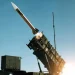 MIM-104 Patriot surface-to-air missile system launching an interceptor at night against an incoming ballistic target.