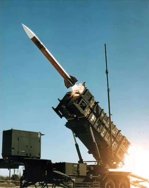 A MIM-104 Patriot surface-to-air missile launching during a high-intensity air defense intercept maneuver.