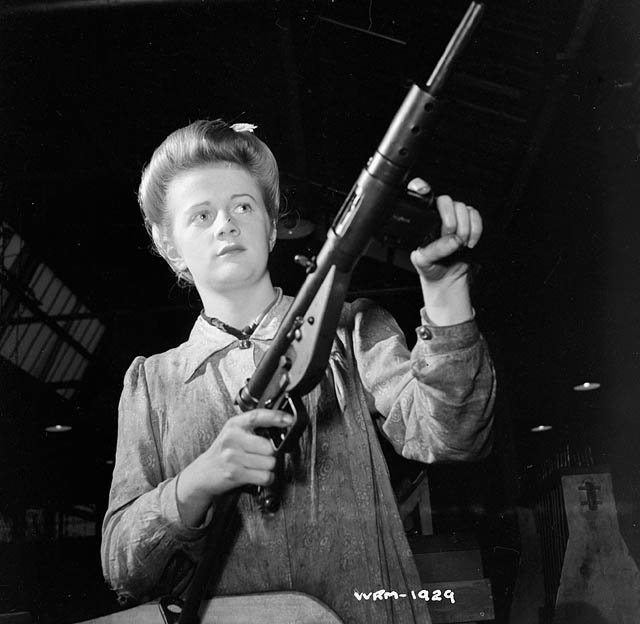Worker posing with a Sten Mk II in the factory on 26 May 1942