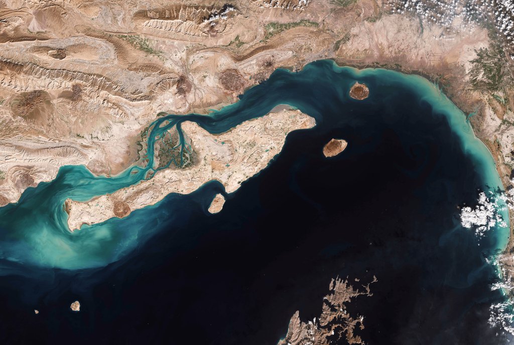 Overhead satellite view of the Strait of Hormuz highlighting Larak Island and commercial shipping lanes.