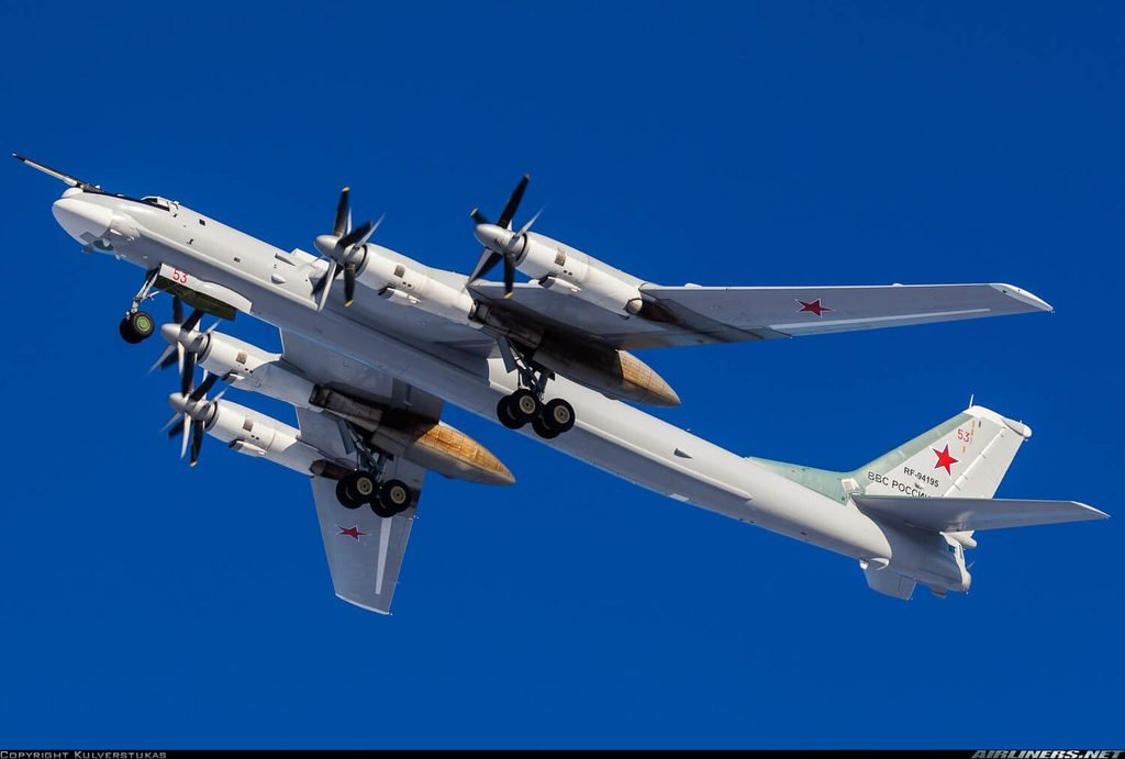 Tu-95 strategic bomber in flight, showcasing its swept wings and four turboprop engines.