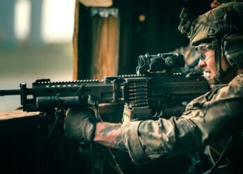A U.S. Army 75th Ranger armed with a KAC LAMG having an ELCAN Specter prism sight at the upper receiver's picatinny rail.
