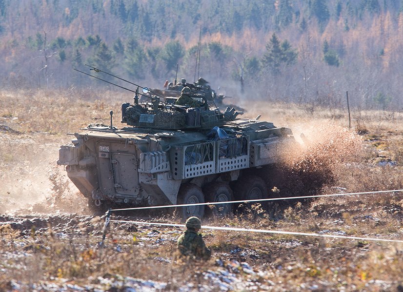 Members of 2nd Battalion, Princess Patricia's Canadian Light Infantry advance on an objective with the support of a Light Armoured Vehicle during a Platoon level group attack with live firing during Exercise